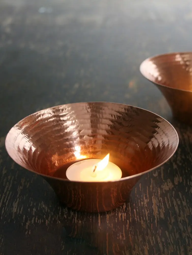 Copper bowl holding a lit tea light