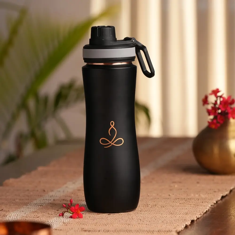 Dark copper sipper bottle with carry loop on a table with a cloth runner