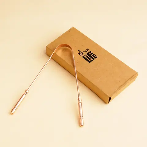 Tongue cleaner leaning on its kraft box