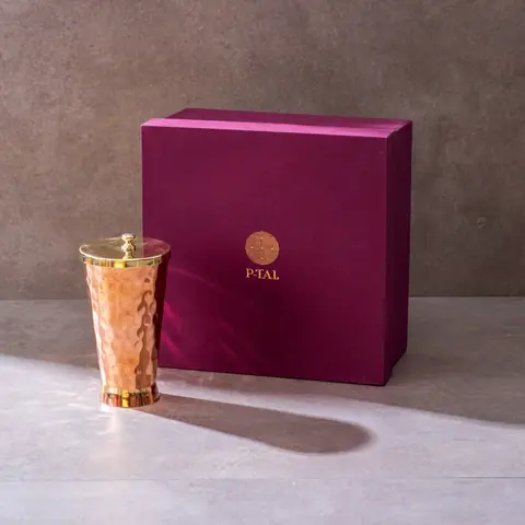 The tumbler beside its dark plum gift box