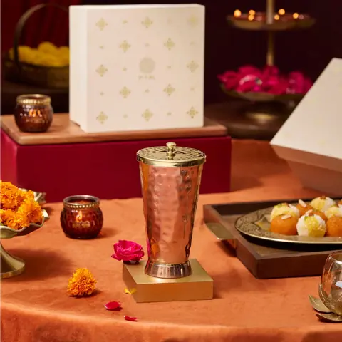 The tumbler in a styled scene with sweets and a gift box
