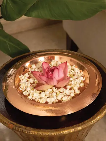 Copper urli with a lotus and white flowers