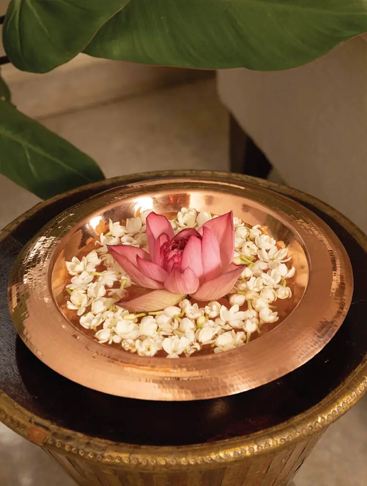 Copper urli with a lotus and white flowers