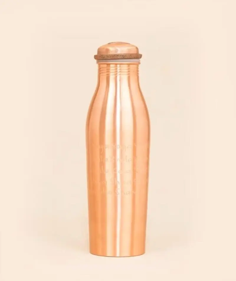 Copper water bottle standing upright on a peach ground