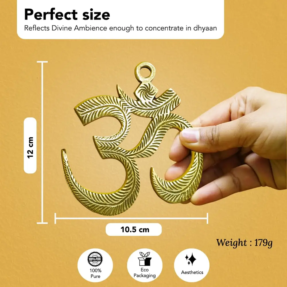 A hand holding the brass Om to show its size