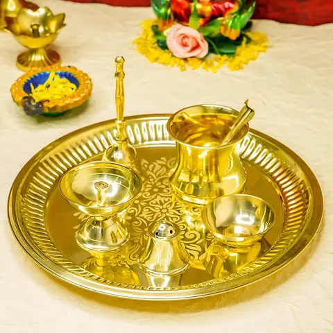 The thali set on a cream cloth with marigold garlands and lamps