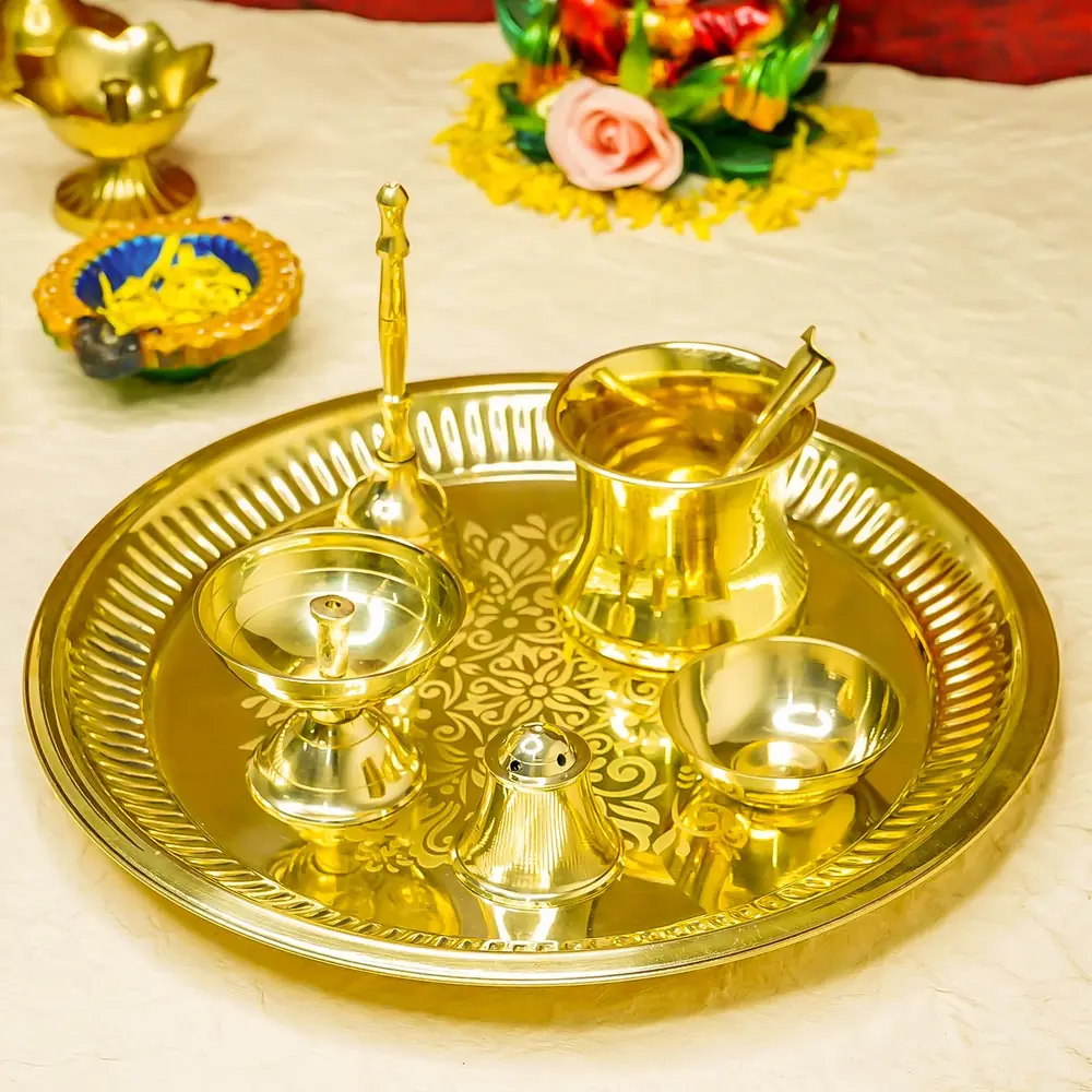 The thali set on a cream cloth with marigold garlands and lamps