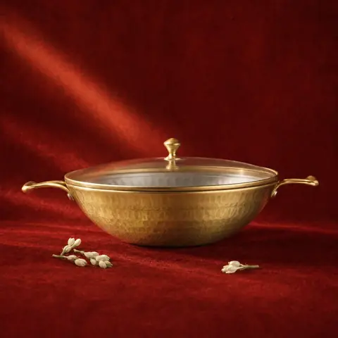 The kadhai on a red cloth with small brass figures