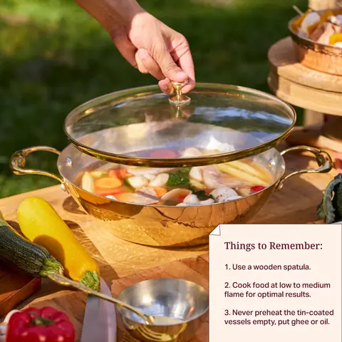 A hand lifting the lid of the kadhai over vegetables