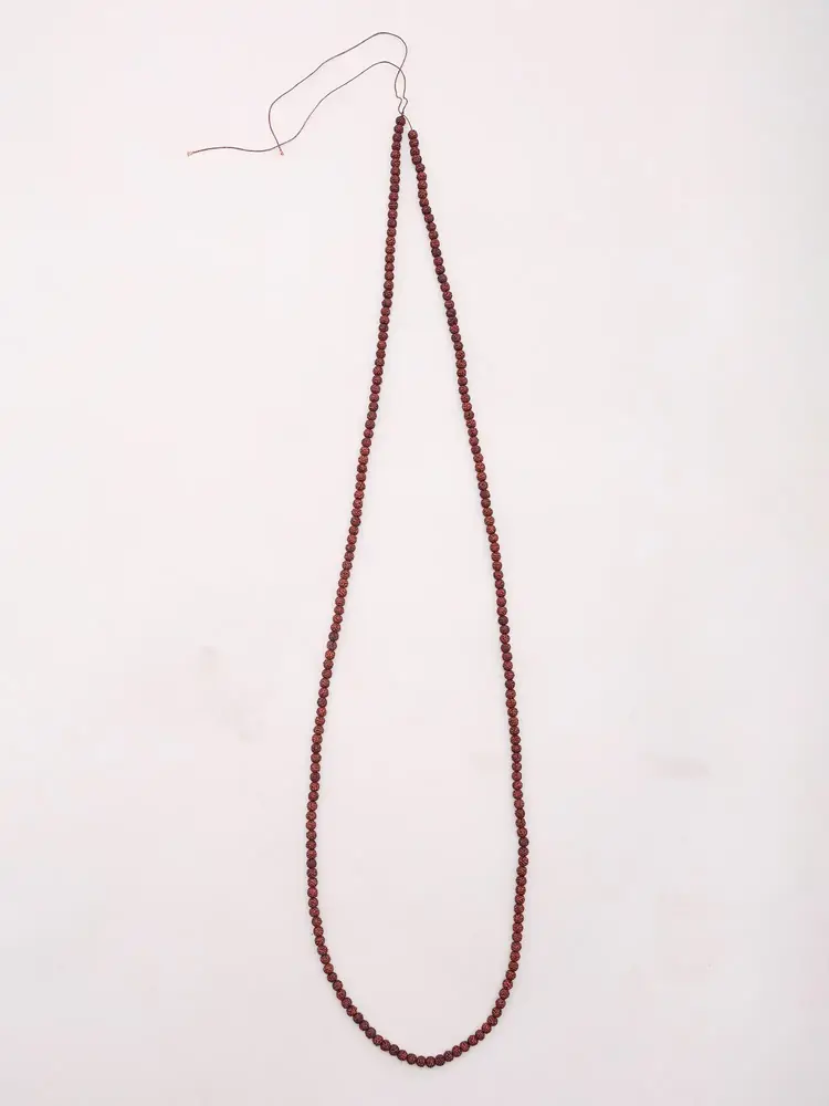 Natural rudraksha mala laid out as a long loop