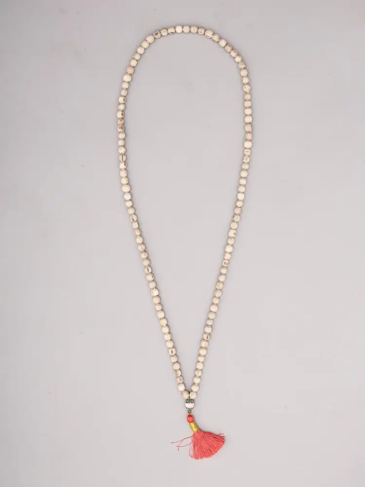 Tulsi bead mala laid out with its red tassel