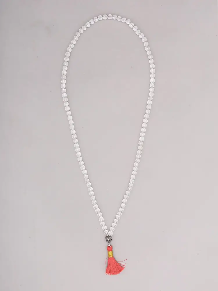 Clear quartz mala laid out with its red tassel