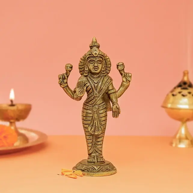 Standing brass Lakshmi idol on a peach ground