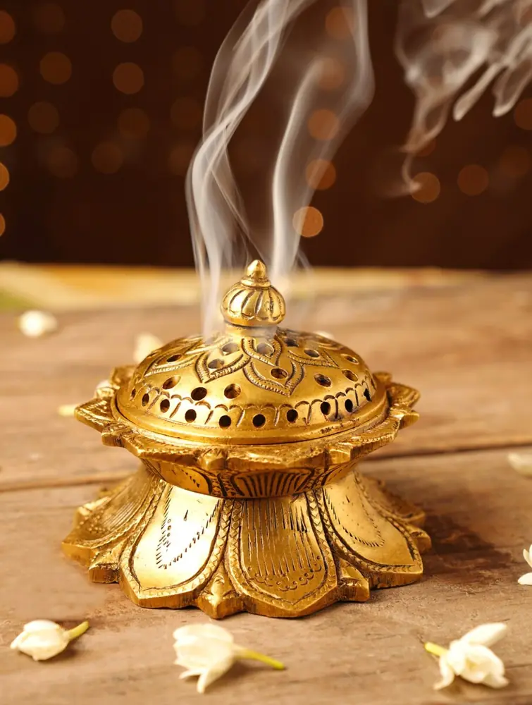 Brass fumer with smoke rising from the pierced lid