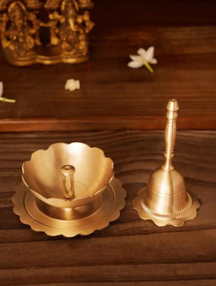 Brass bell and lotus petal holder on grey
