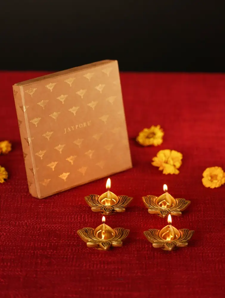 Diyas beside a cream gift box on red cloth