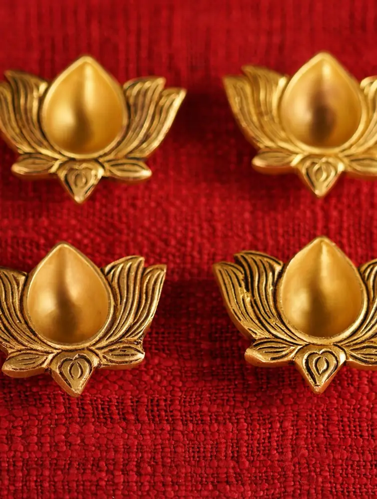 Four brass lotus diyas close up