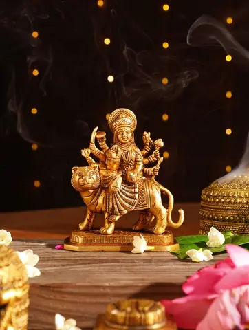 Durga idol beside incense smoke and flowers