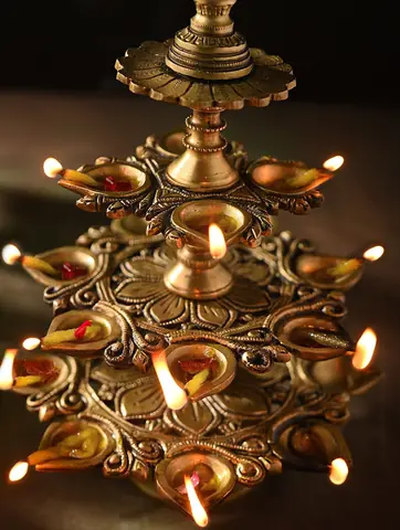 The tiered lamp lit with flames in several cups