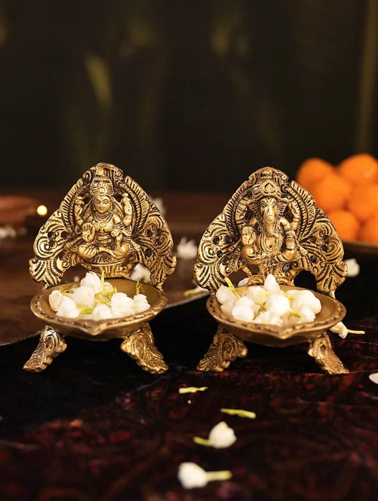 Two brass lamps with carved seated figures and flowers