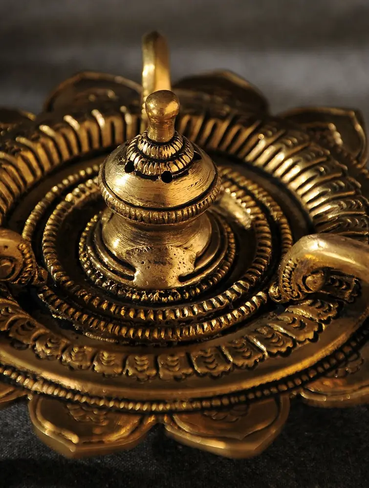 Close view of the ringed brass piece with a centre finial