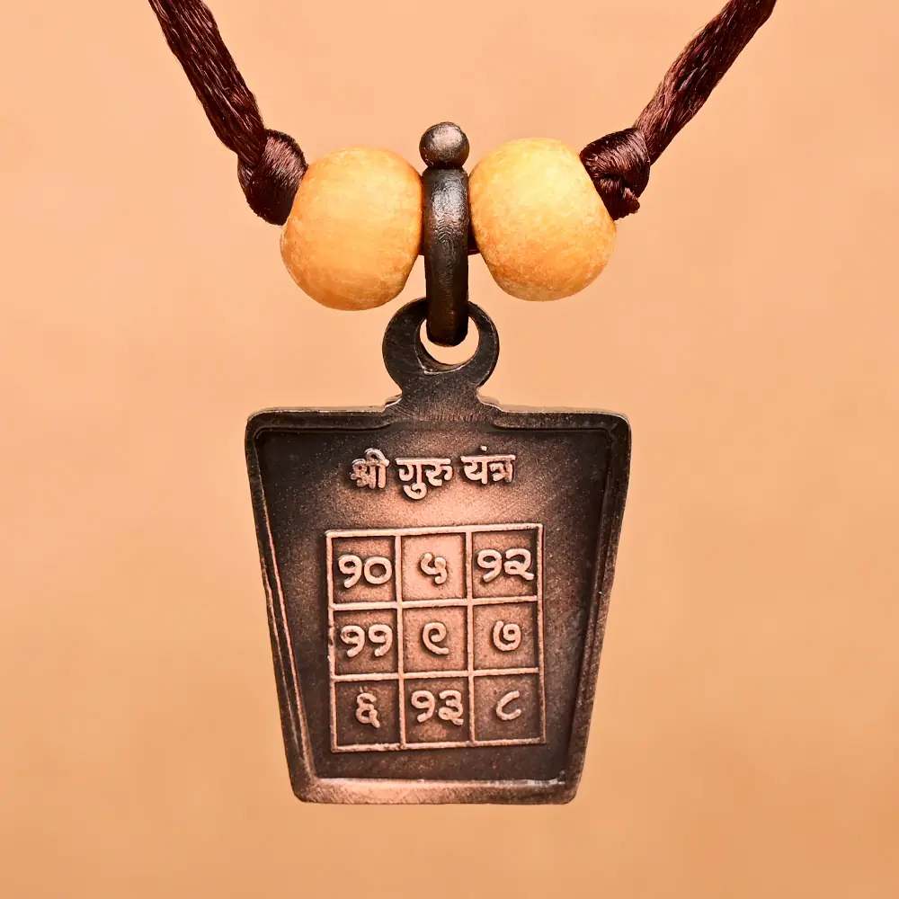 Guru yantra side of the copper locket on a thread