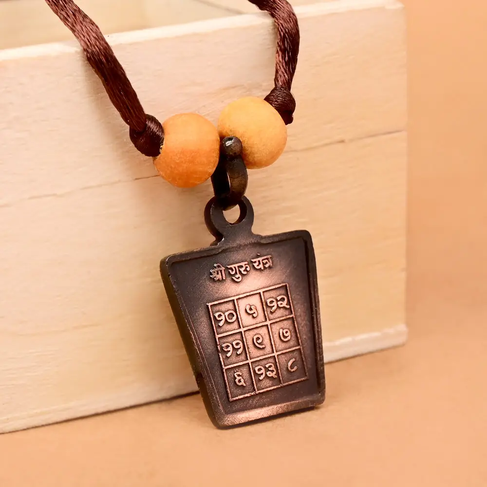 The yantra side on a brown cord with two beads