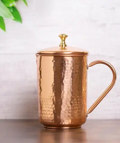 The copper jug on a grey table in front of a wall