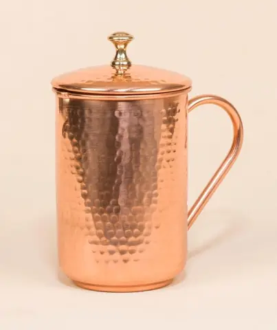 Copper jug with the lid resting beside it
