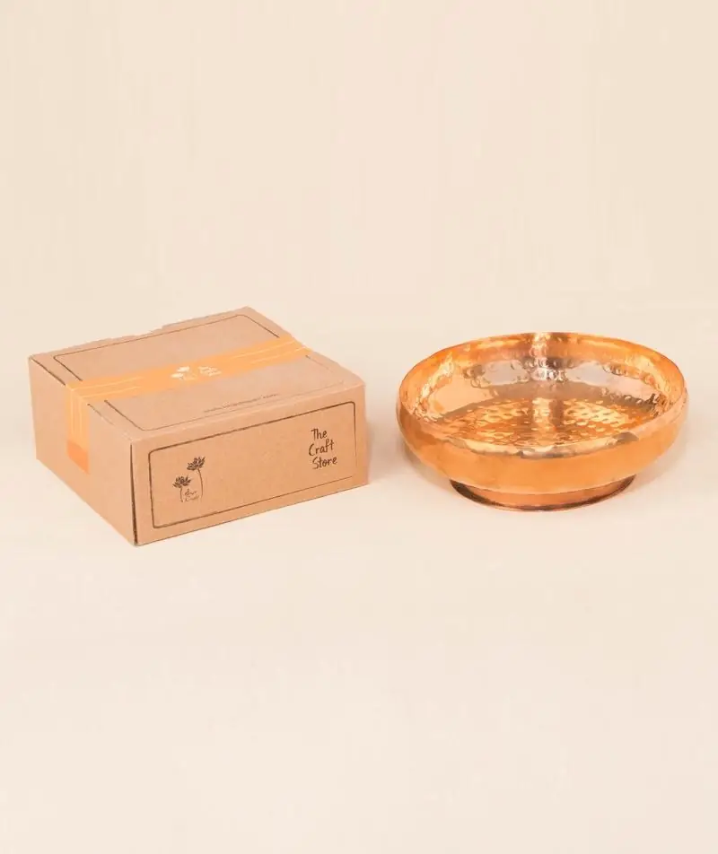 A bowl filled with yellow and pink flowers and a lamp