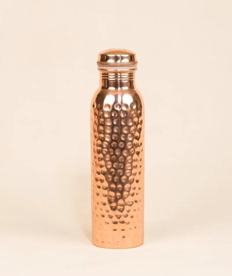 Hammered copper bottle on a plain peach ground