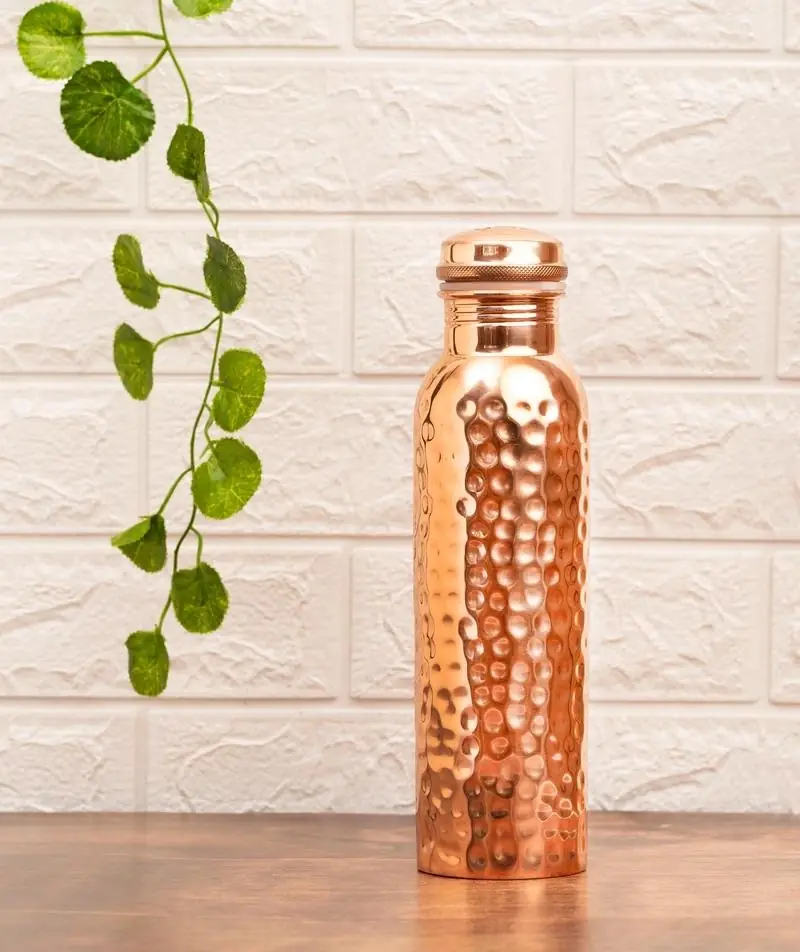 The bottle on a wooden shelf beside a trailing plant