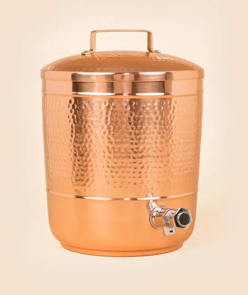 Hammered copper pot with a lid and tap, seen from the front