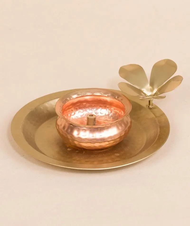 Hammered flower lamp on a pale ground with a green leaf behind