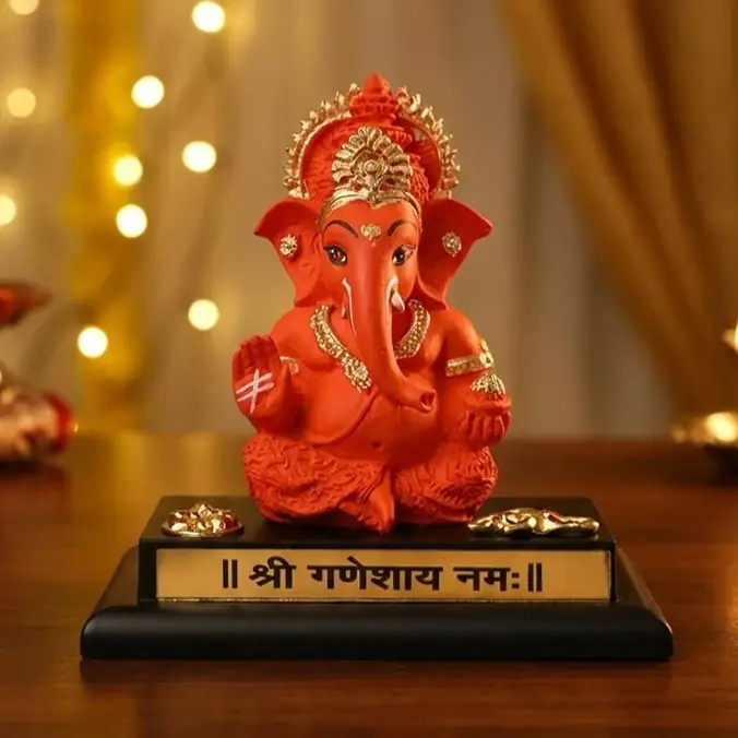 Saffron resin Ganesha on a black base with a gold mantra