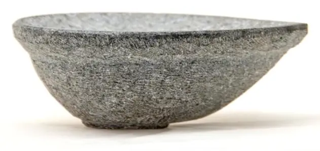 A second view of the grey stone diya on a pale ground