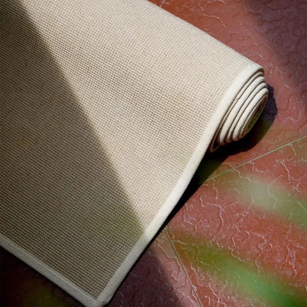 Pale handwoven bamboo and linen yoga mat rolled at one end