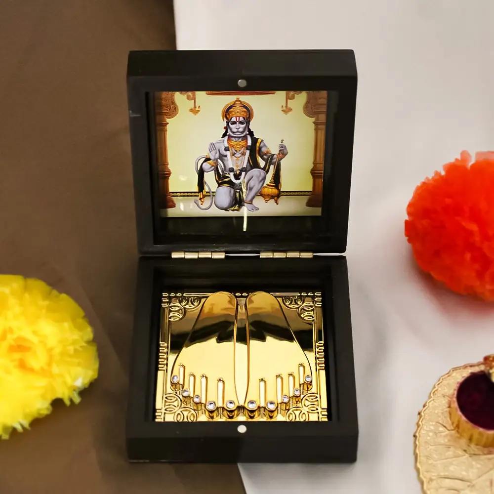 Black box open showing a Hanuman image above and gold feet below