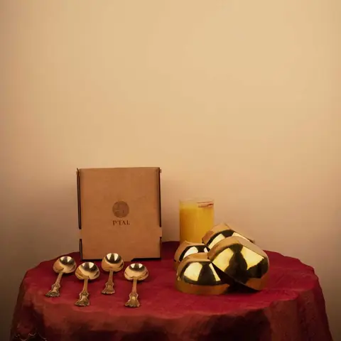 A gift box with spoons and bowls on a red cloth