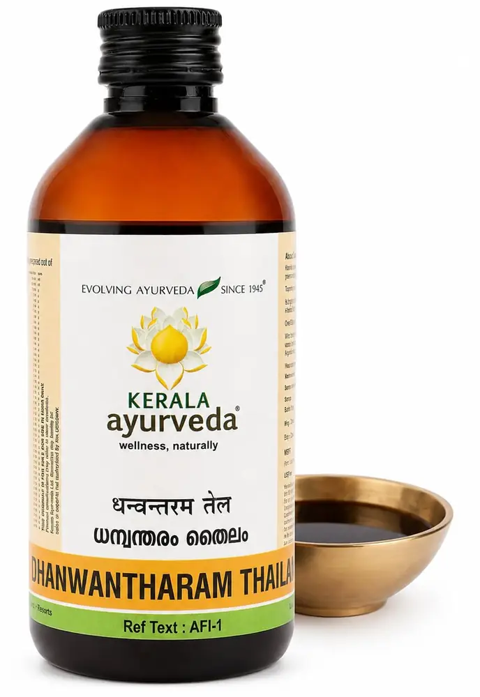 Bottle of Kerala Ayurveda Dhanwantharam Thailam beside a small brass bowl