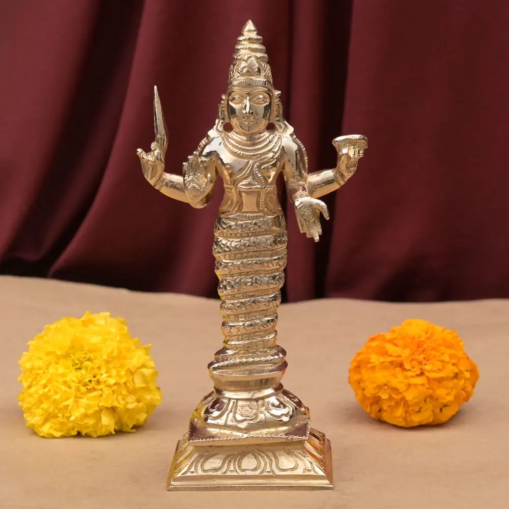 Ketu bronze idol standing on its dais with marigolds