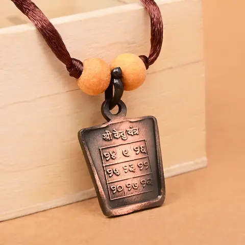The yantra side on a brown cord with two beads