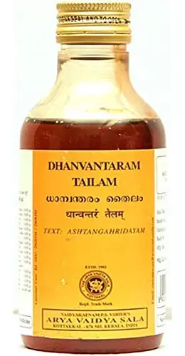 Amber bottle of Kottakkal Dhanwantharam Tailam with its orange label