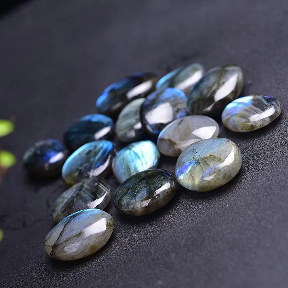 A heap of tumbled labradorite stones on a dark cloth