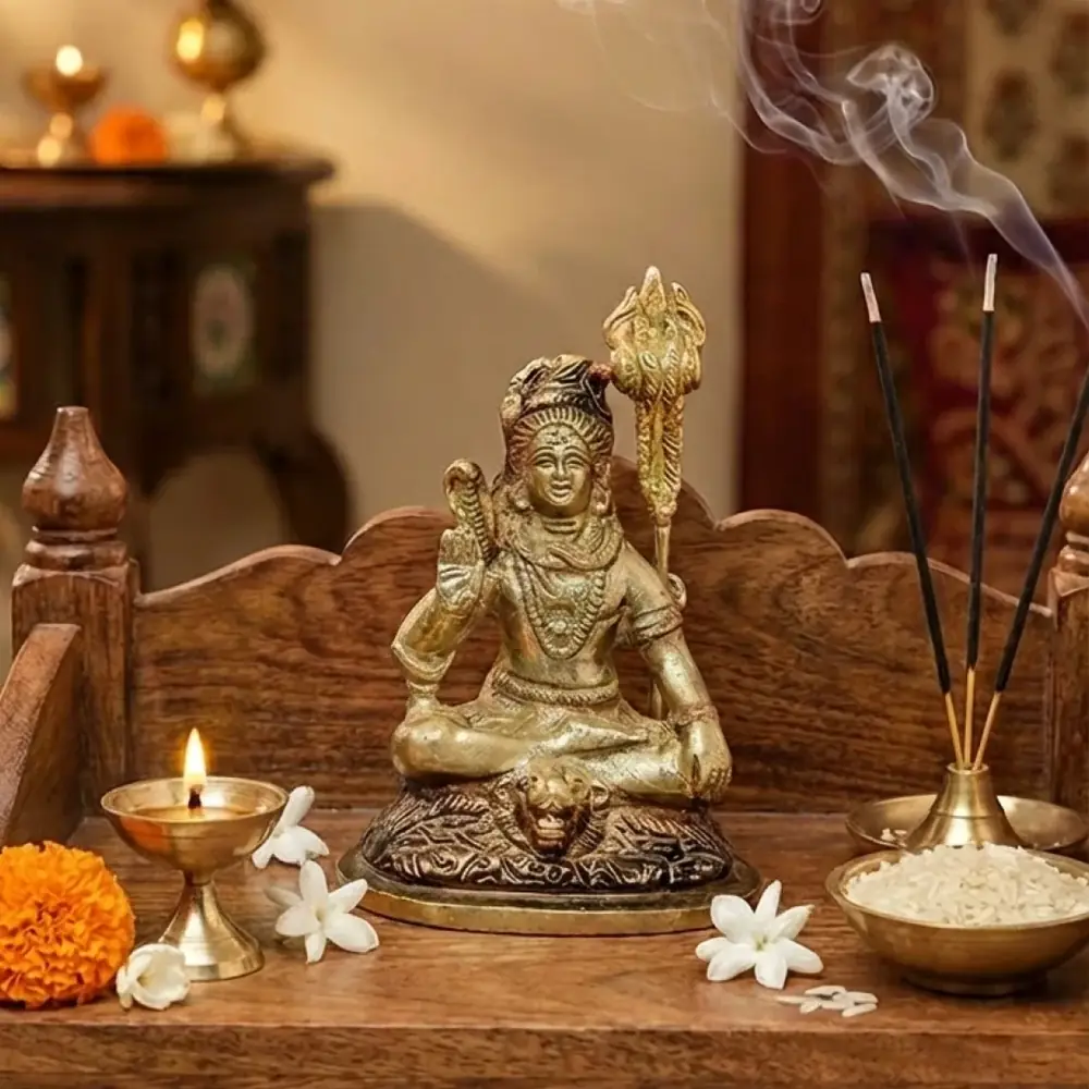 The idol on a wooden shelf with lamps, incense and flowers