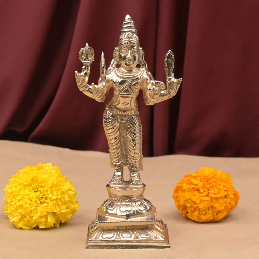 Mangal bronze idol standing on its dais with marigolds