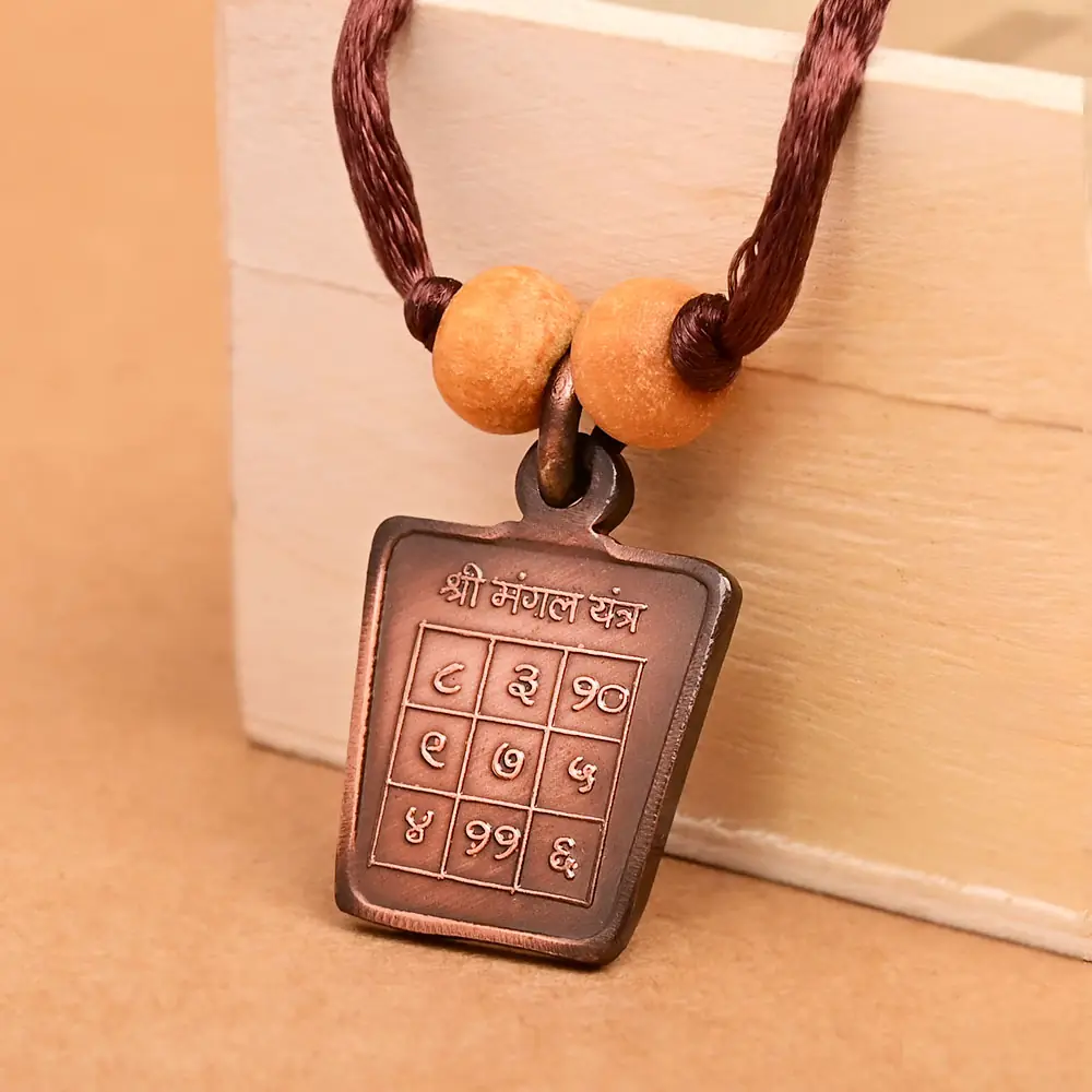 The yantra side on a brown cord with two beads