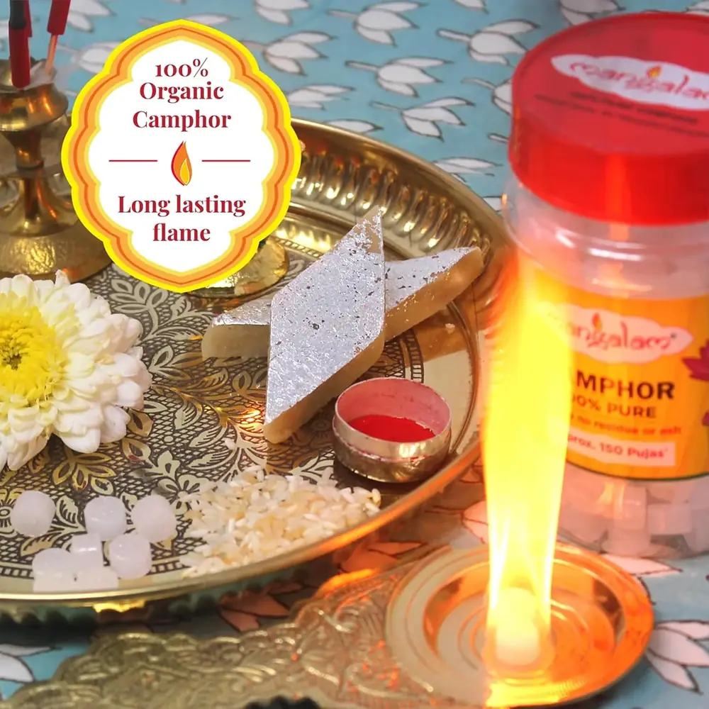 Camphor tablets burning on a puja plate with flowers