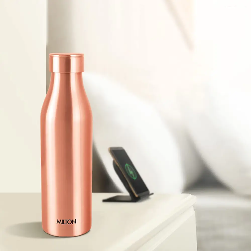 The bottle on a bedside table beside a phone