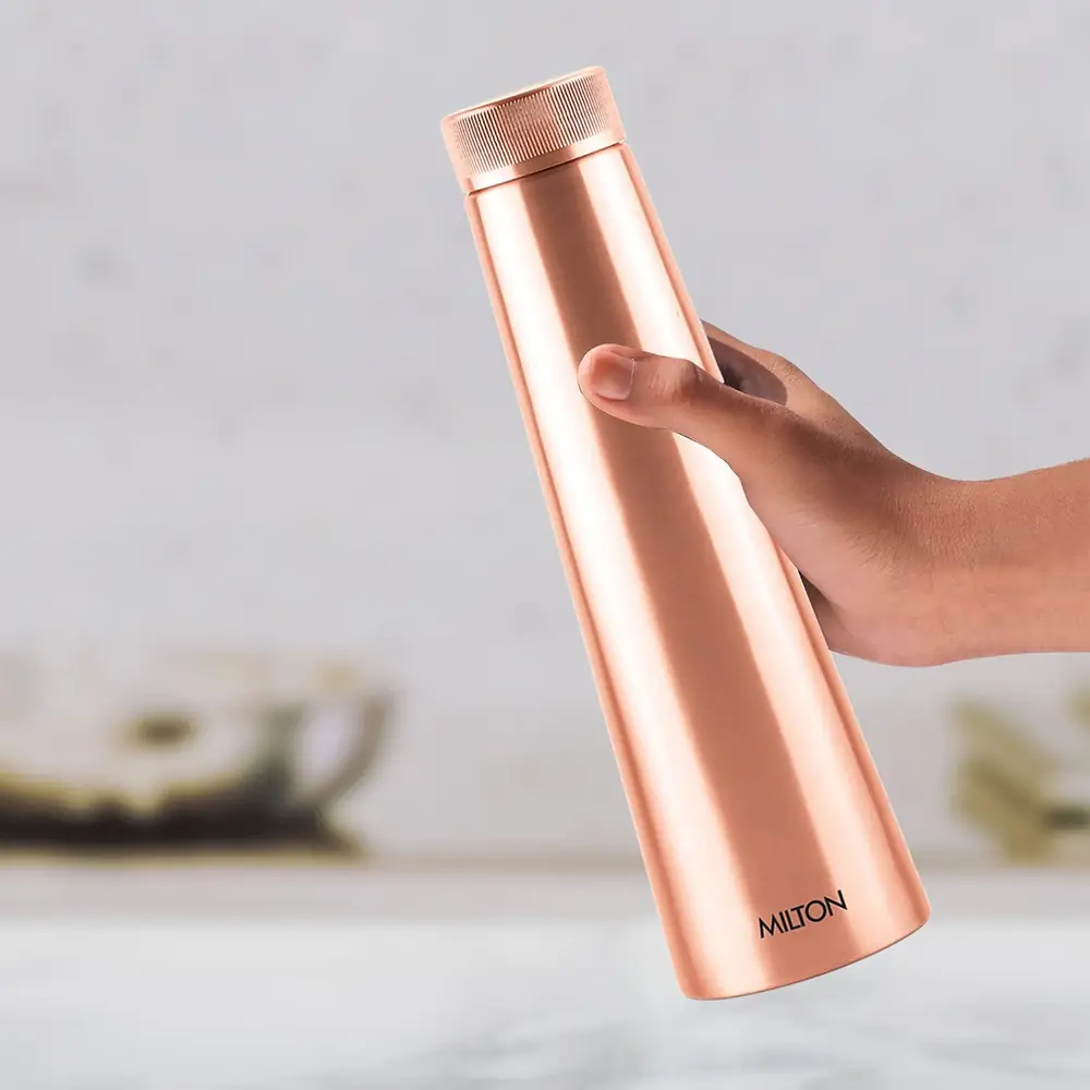 A hand holding the bottle